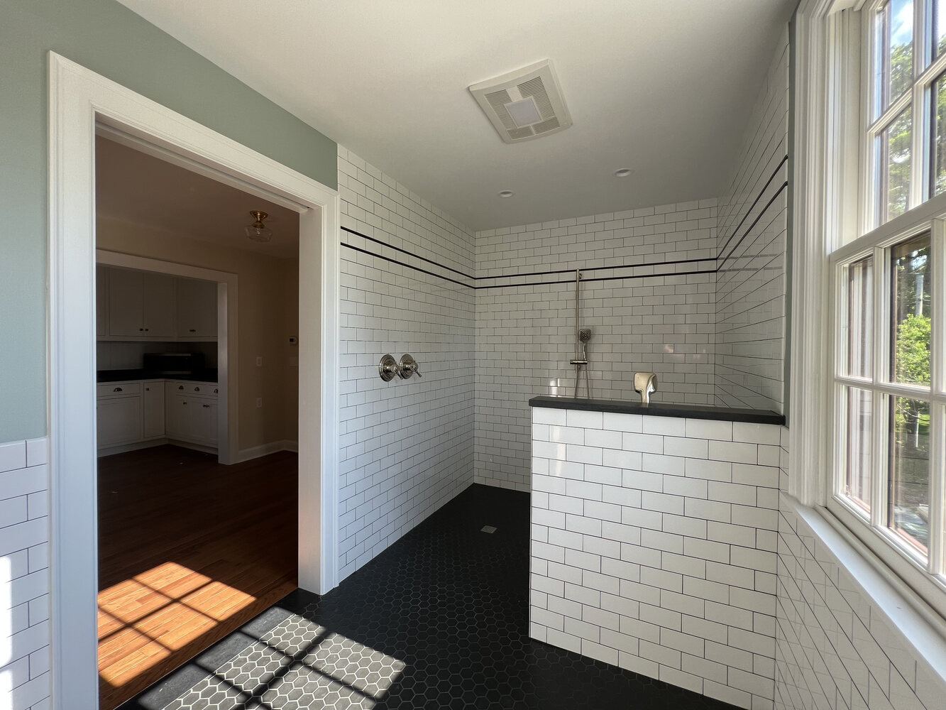 Modern bathroom layout with walk-in shower and transitional entry to kitchen in South Bend home by Barbour Construction. Modern bathroom layout with walk-in shower and transitional entry to kitchen in South Bend home by Barbour Construction.