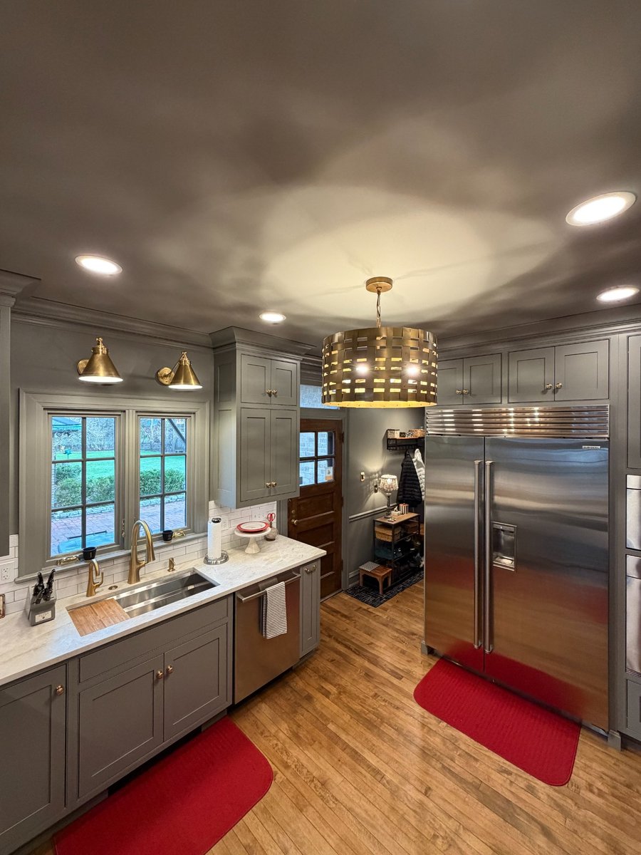 south bend kitchen remodel sink wall upper cabinets brass sconces closeup