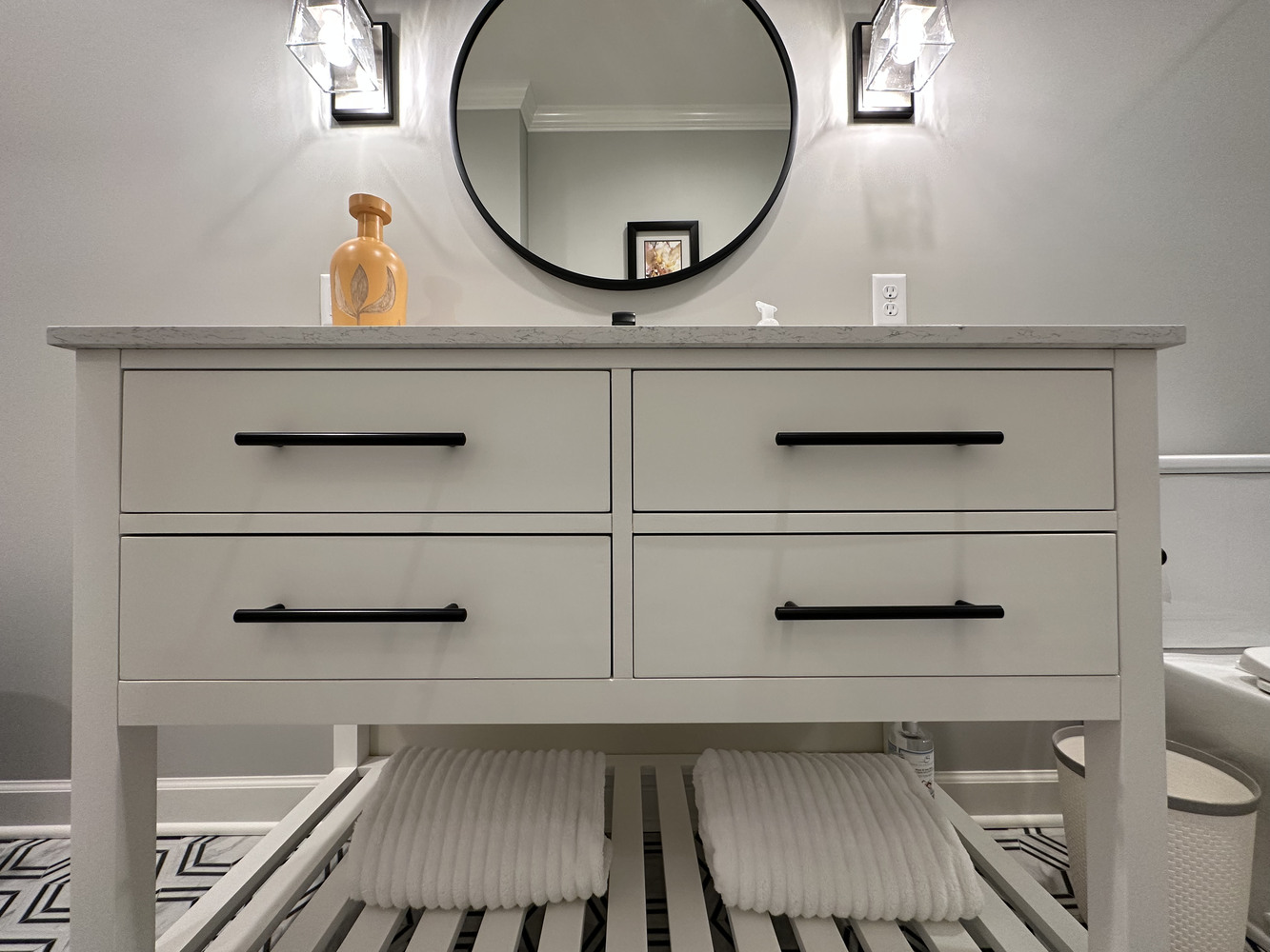 Close-up of white bathroom vanity with black handles in custom New Carlisle home by Barbour Construction.