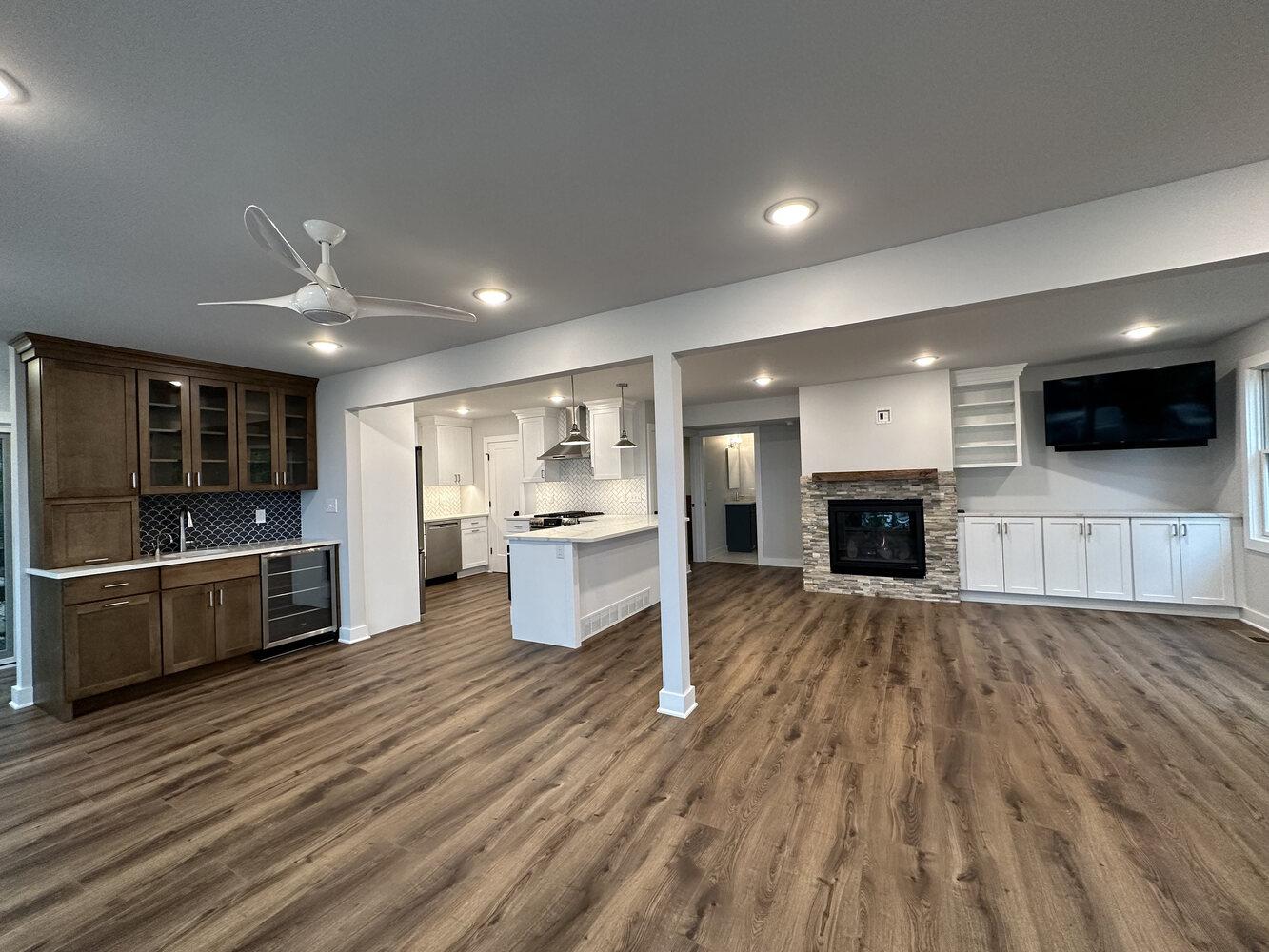 Open-concept kitchen and living room with hardwood flooring in Sawyer, MI home by Barbour Construction.